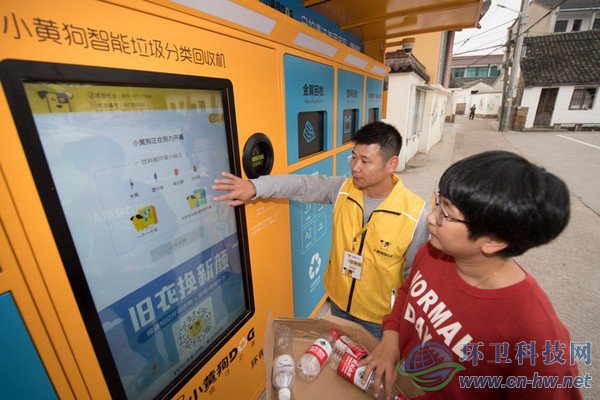 10月30日，在道場(chǎng)鄉(xiāng)錢山下村，工作人員（左）指導(dǎo)村民在智能回收機(jī)上進(jìn)行垃圾分類回收。